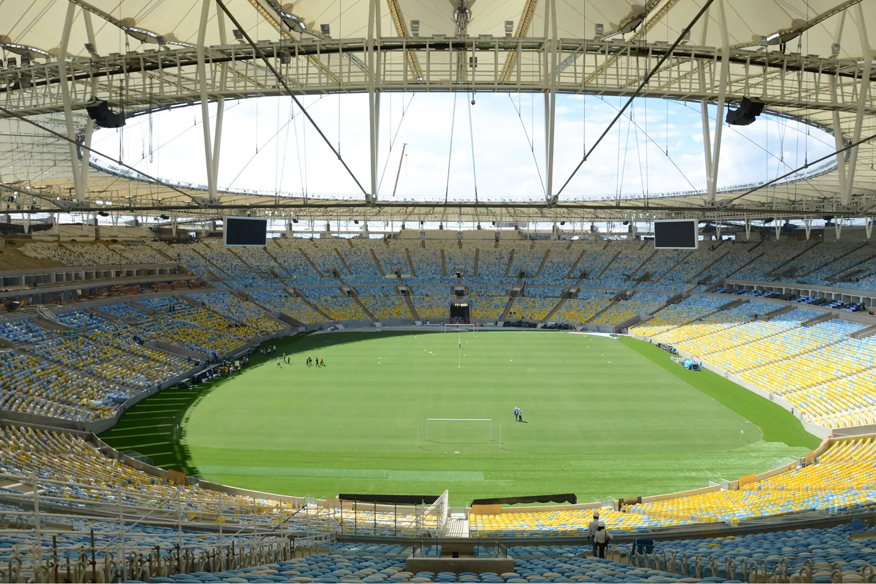 O interior do Maracanã visto das arquibancadas, com o gramado e as cadeiras azuis e amarelas